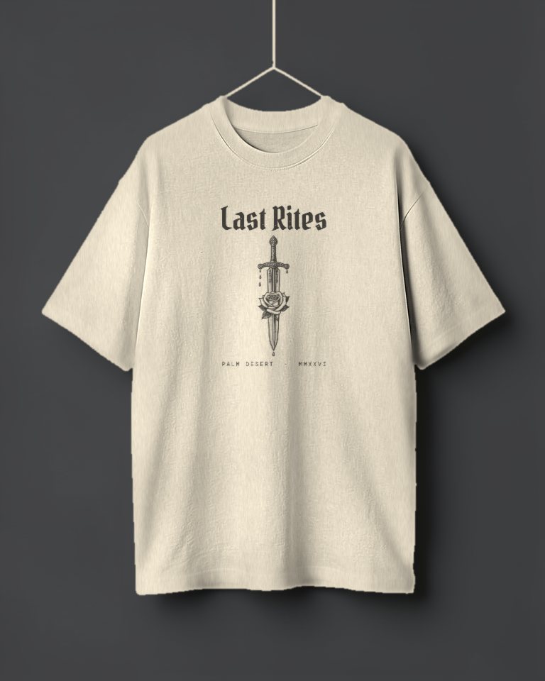 An oversized bone off-white tee hanging on a thread, printed in washed black with Last Rites in gothic letters over a tall ornate tattoo-flash dagger piercing a rose, and Palm Desert, MMXXVI.